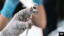 FILE - A pharmacist loads a syringe with monkeypox vaccine at a pop-up vaccination site in West Hollywood, California, Aug. 3, 2022.