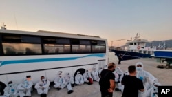 This photo provided by the Hellenic Coast Guard shows migrants at a port on the southeastern Aegean Sea island of Kos, Greece, after a rescue operation, Aug. 10, 2022. (Hellenic Coast Guard via AP)