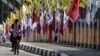 Seorang perempuan bersepeda melewati bendera partai politik jelang Pemilu 2019 di Banda Aceh, 23 Maret 2019. (Foto: AFP/CHAIDEER MAHYUDDIN)