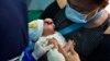 FILE - A mother holds her infant as a member of the medical staff administers the vaccination for tuberculosis at a community health center in Banda Aceh, Indonesia, on June 15, 2020. 