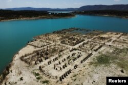 The remains of the Royal Site of La Isabela bathhouse emerge from the low waters of the Buendia reservoir, in Sacedon, Spain, Aug. 7, 2022.