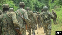 FILE - Ugandan troops are seen on a road in the Beni district of the Democratic Republic of Congo, Dec. 8, 2021. This week, a contingent from Burundi arrived in the DRC as part of an East African regional force deployment to counter violence by rebel groups.