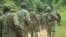 FILE - Ugandan troops are seen on a road in the Beni district of the Democratic Republic of Congo, Dec. 8, 2021. This week, a contingent from Burundi arrived in the DRC as part of an East African regional force deployment to counter violence by rebel groups.