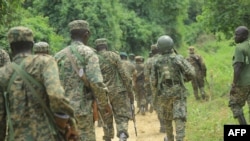 FILE - Ugandan troops are seen on a road in the Beni district of the Democratic Republic of Congo, Dec. 8, 2021. On November 30, the Ugandan air force and artillery shelled areas in Ituri and North Kivu, Congolese provinces bordering Uganda, wehre the insurgent ADF operated.