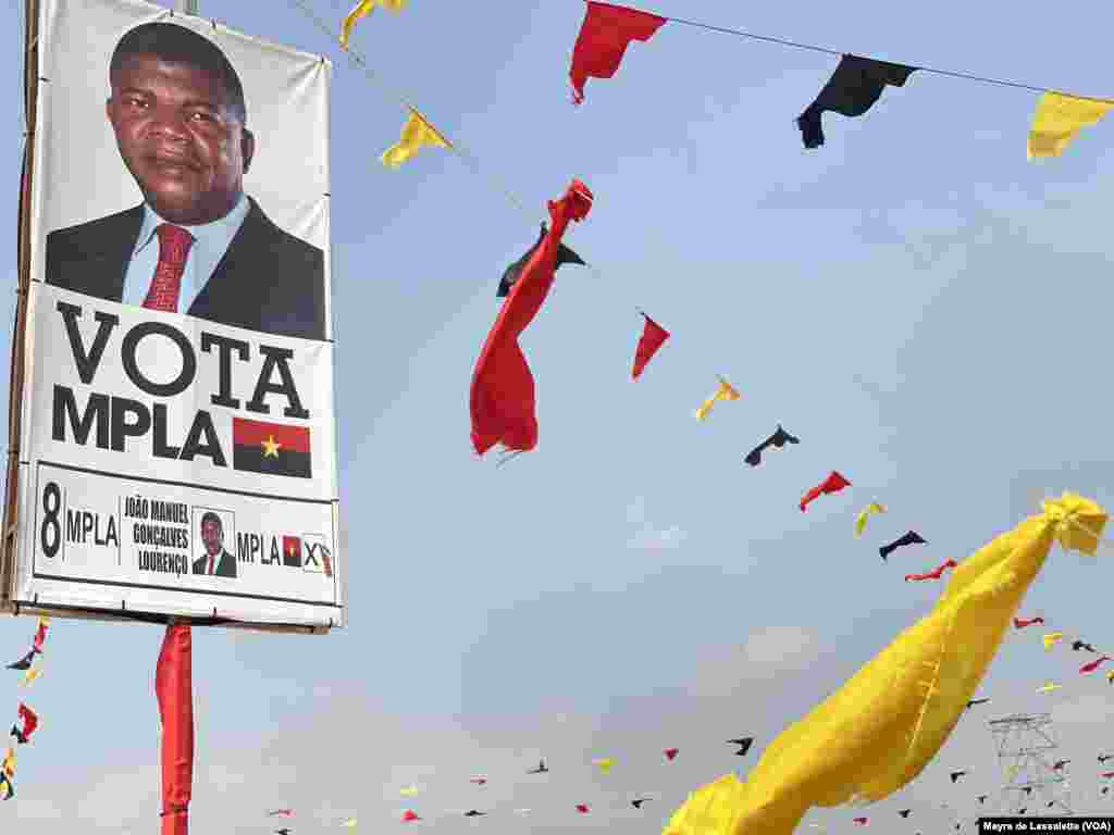 Cartaz com o candidato João Lourenço, ao pé de bandeiras com as cores do MPLA, partido no poder, Camama, Luanda.