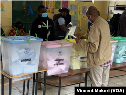 Seorang pria memasukkan surat suaranya di sebuah TPS di Nairobi pada pemilihan umum 2022 di Kenya, 9 Agustus 2022. (Vincent Makori/VOA)