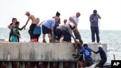 Residents help Cuban migrants to shore near Key West, Fla., Aug. 12, 2022.