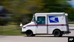 Un camión de correo se mueve por una calle el martes, 18 de agosto de 2020, en Fox Point, Wisconsin.