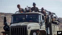 FILE - Ethiopian government soldiers ride in the back of a truck on a road near Agula, north of Mekelle, in the Tigray region of northern Ethiopia on May 8, 2021.