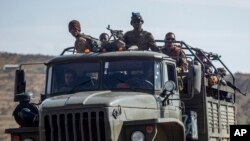 FILE - Ethiopian government soldiers ride in the back of a truck on a road near Agula, north of Mekelle, in the Tigray region of northern Ethiopia, May 8, 2021.