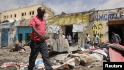 FILE - Residents look at the aftermath of an al-Shabab militant attack in Mogadishu, Aug. 21, 2022. 