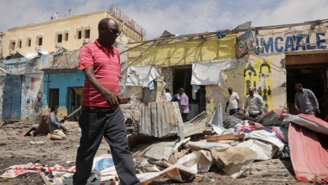 FILE - Residents look at the scene of an al-Qaida-linked al-Shabab group militant attack, in Mogadishu, Somalia, Aug. 21, 2022.