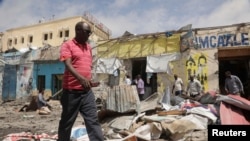 Sejumlah warga mengamati tempat lokasi serangan yang dilancarkan oleh kelompok militan al Shabaab, yang terkait dengan Al Qaeda, di Mogadishu, Somalia, pada 21 Agustus 2022. (Foto: Reuters/Feisal Omar)