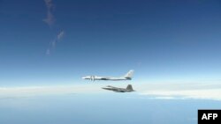 资料照片：北美防空司令部公布的照片显示美军F-22“猛禽”战斗机拦截一架俄罗斯轰炸机。(2020年6月16日) 