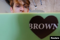 Hlib Burtsev, who is from Ukraine, reads his email in the common area outside his dorm room ahead of his first year at Brown University in Providence, Rhode Island, U.S., August 16, 2022. (REUTERS/Brian Snyder)