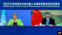 In this file photo released by Xinhua News Agency, A screen showing Chinese President Xi Jinping, right, holds a virtual meeting with United Nations High Commissioner for Human Rights Michelle Bachelet, May 25, 2022.