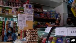 Carteles muestran los precios de los productos vendidos en bolívares en una pequeña tienda en Caracas, Venezuela, el jueves 12 de mayo de 2022.