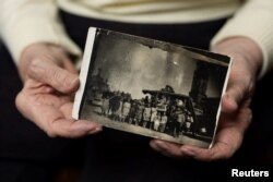 Janina Iwanska, 94, penyintas Auschwitz, memegang foto perjalanan ke Polandia dalam sesi foto Reuters menjelang 80 tahun pembebasan Auschwitz, di Warsawa, 7 Januari 2025. (Foto: REUTERS/Kacper Pempel)