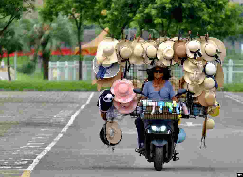 Wang Shang-chi, 75, a mobile hats vender, rides his bike on a parking lot next to the Taipei City Zoo, Taiwan.