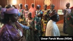 Le président nigérian Muhammadu Buhari et les lycéennes de Chibok libérées récemment.