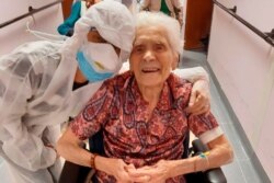 In this photo taken on April 1, 2020, 103-year-old Ada Zanusso, poses with a nurse at the old people's home "Maria Grazia" in Lessona, northern Italy, after recovering from Covid-19 infection.