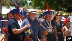 FILE - Brazil's President Luiz Inacio Lula da Silva, second left, and first lady Rosangela Silva, second from right, are received by an Indigenous party on the Raposa Serra do Sol Indigenous reserve in Roraima state, Brazil, March 13, 2023.