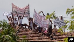 Death-row inmates of Sri Lanka's Welikada prison protest with banners from the roof of the prison in Colombo, Sri Lanka, June 25, 2021. The banners read Banners read 'Treat all inmates equally,' 'Grant bail on appeal applications,' and other slogans.