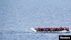 FILE - Migrants wait to be rescued by an NGO crew in the Mediterranean sea off the Libya coast, June 18, 2017.