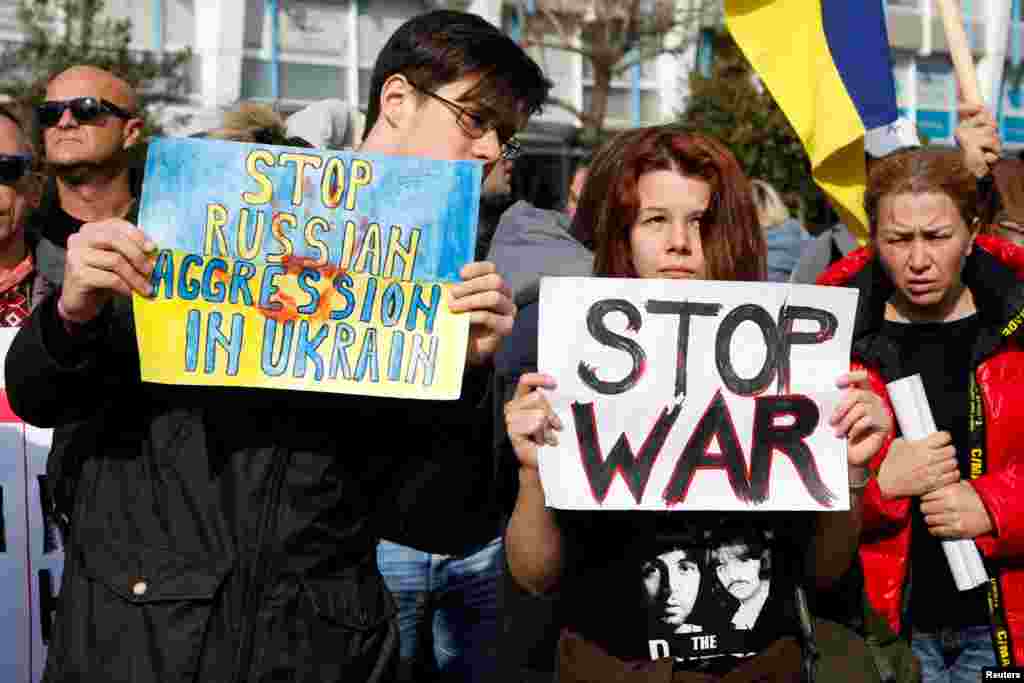 People hold signs during an anti-war protest march, after Russia launched a massive military operation against Ukraine, in Podgorica, Montenegro, Feb. 27, 2022. 