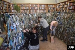 Los voluntarios fabrican redes de camuflaje para el ejército ucraniano en una biblioteca en la ciudad de Lviv, en el oeste de Ucrania, el 1 de marzo de 2022.