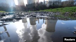 Në ujë reflektohet tymi që çlirohet në një central me qymyr në Kolonjë, Gjermani