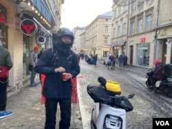 In historic center 22-year-old Marian is grabbing a coffee. He works for the meal-delivery company Glovo, which donates profits to Ukraine’s military. (Jamie Dettmer/VOA)