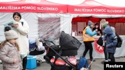 Warga Ukraina yang melarikan diri dari invasi Rusia, berdiri di depan stan bantuan Maltese di Vysne Nemecke, Slovakia, 1 Maret 2022. (REUTERS/Lukasz Glowala)
