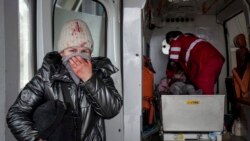 A woman reacts as paramedics perform CPR on a girl who was injured during shelling, at city hospital of Mariupol, eastern Ukraine, Sunday, Feb. 27, 2022.