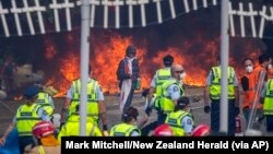 Demonstrators set fire to tents, mattresses and chairs at a protest opposing coronavirus vaccine mandates in Wellington, New Zealand, March 2, 2022. 