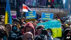 People gather in Times Square to denounce the Russian invasion of Ukraine, Feb. 26, 2022, in New York.