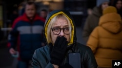 Una mujer reacciona al sonido de las sirenas que anuncian nuevos ataques, afuera de un supermercado en el centro de Kiev, Ucrania, el 28 de febrero de 2022.