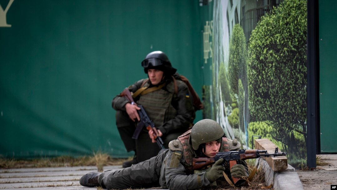 Binh lính Ukraine trong tư thế chiến đấu tại trung tâm thủ đô Kyiv hôm 25/2. Tình báo Anh nói quân Nga đạt đuợc ít tiến bộ trong cuộc tiến công vào Kyiv.