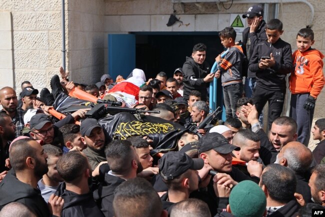 Pelayat membawa mayat dua orang Palestina yang dibunuh oleh pasukan Israel, di luar kamar mayat rumah sakit Jenin di Tepi Barat utara pada 1 Maret 2022. (JAAFAR ASHTIYEH / AFP)