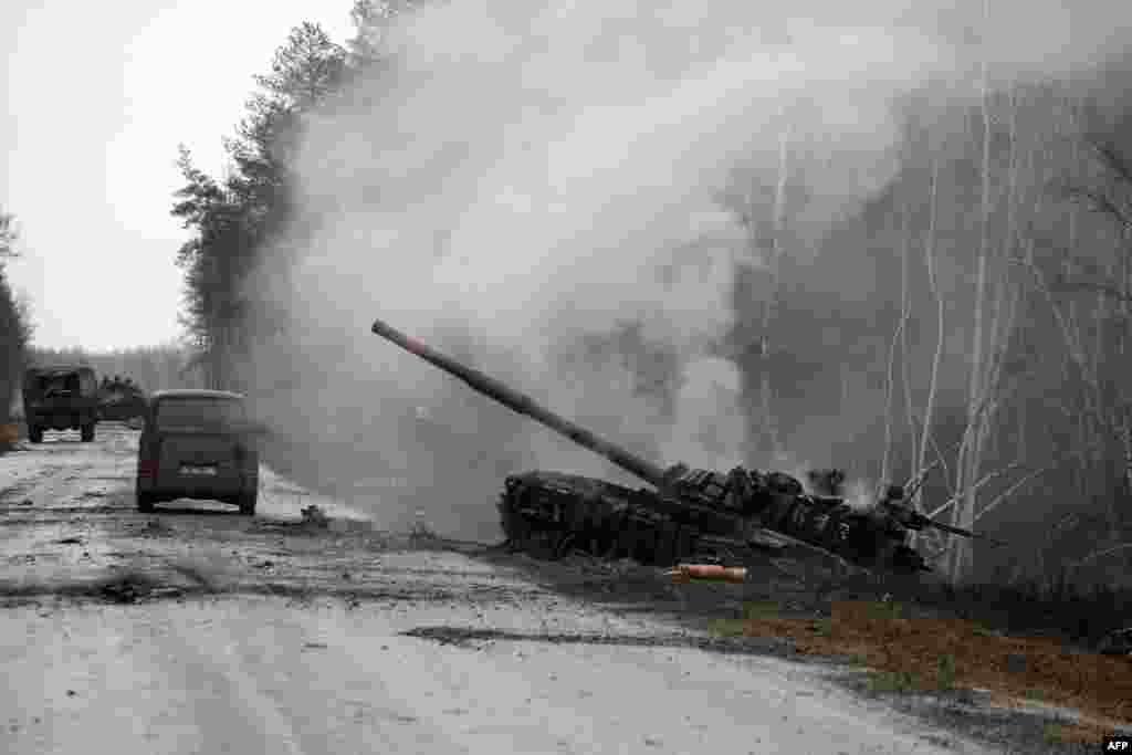 Smoke rises from a Russian tank destroyed by the Ukrainian forces on the side of a road in Lugansk region, Feb. 26, 2022.
