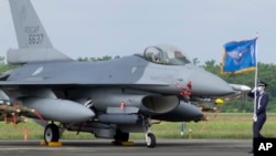 ທະຫານຖືທຸງກອງທັບອາກາດໄຕ້ຫວັນ ຍ່າງຜ່ານເຮືອບິນລົບ F-16V ທີ່ຖືກປັບປຸງໃໝ່ຢູ່ຖານທັບອາກາດ ເຈຍຢີ, ໄຕ້ຫວັນ, 18 ພະຈິກ, 2021. 
