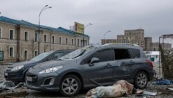 The body of a victim lies next to damaged cars in the central square following shelling of the City Hall building in Kharkiv, Ukraine, March 1, 2022.