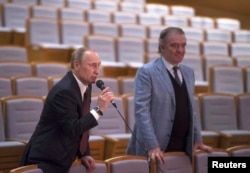 FILE - Russian President Vladimir Putin, left, directs a rehearsal with Valery Gergiev, then-artistic director of the Mariinsky Theatre, in St. Petersburg, Jan. 7, 2014.