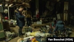 A group of Kyiv civilians gather in a basement downtown to make Molotov Cocktails to be used against Russian troops in Kyiv, Ukraine, Feb. 25, 2022.