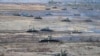 FILE - Tanks move during the Union Courage-2022 Russia-Belarus military drills at the Obuz-Lesnovsky training ground in Belarus, Feb. 19, 2022.