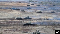 FILE - Tanks move during the Union Courage-2022 Russia-Belarus military drills at the Obuz-Lesnovsky training ground in Belarus, Feb. 19, 2022.