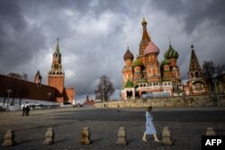 Seorang perempuan berjalan di luar Kremlin, Lapangan Merah dan Katedral St. Basil di Moskow tengah pada 22 Februari 2022. (Foto: AFP)