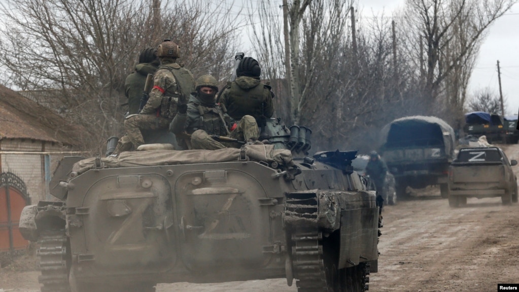 Los miembros del servicio de las tropas pro-rusas en uniformes sin insignias se ven encima de un vehículo blindado en el asentamiento controlado por los separatistas de Buhas (Bugas), mientras continúa la invasión de Ucrania por parte de Rusia, en la región de Donetsk, Ucrania.