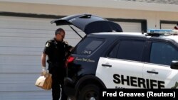 ARCHIVES - Un enquêteur met des sacs de preuves dans un véhicule lors d'une enquête à Citrus Heights, en Californie, aux États-Unis, le 26 avril 2018. 