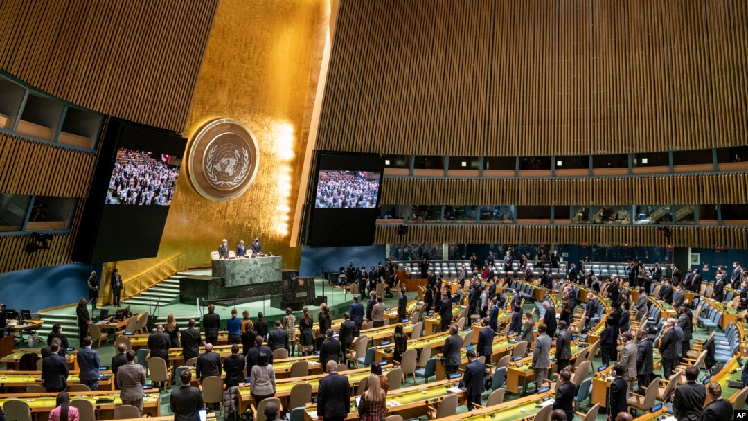 FILE - Delegations stand for a moment of silence during an emergency session of the U.N. General Assembly, Feb. 28, 2022, at United Nations Headquarters in New York.